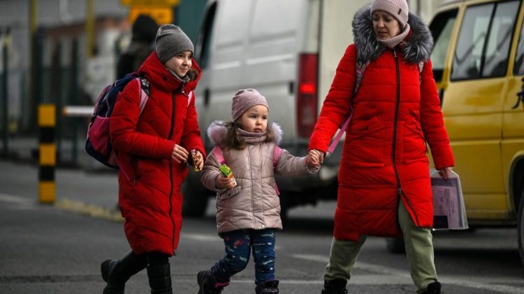 Rifugiati dall'Ucraina attraversano il confine con la Polonia a Korczowa. Per le Nazioni Unite già 2,2 milioni persone hanno già lasciato il Paese (AFP)