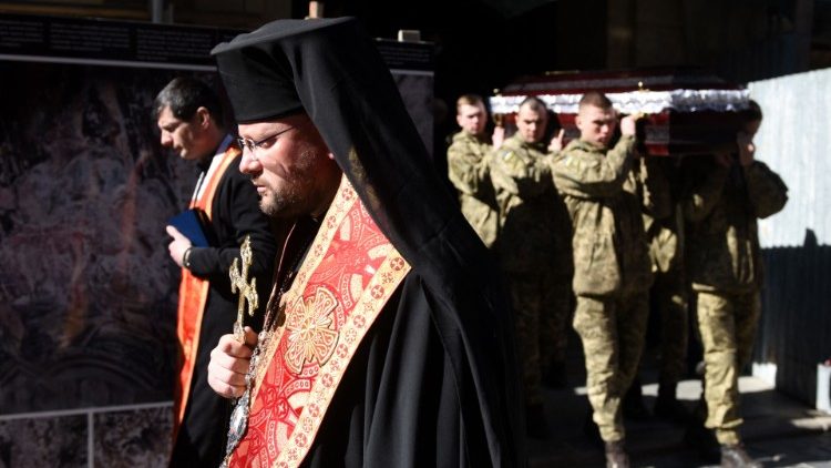 O bispo Stepan Sus lidera um serviço memorial para o major Ivan Skrypnyk, que foi morto durante a invasão da Ucrânia pela Rússia, na Igreja Saints Peter and Paul Garrison, na cidade ucraniana ocidental de Lviv, em 17 de março de 2022. (Foto de Yuriy Dyachishyn / AFP)