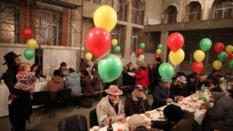 Refugiados judeus ucranianos que fugiram da guerra se reúnem para celebrar o feriado judaico de Purim na sinagoga Chabad-Lubavitch em Chisinau em 16 de março de 2022. - Os refugiados judeus esperam para serem levados para Israel nos próximos dias. (Foto de GIL COHEN-MAGEN/AFP)