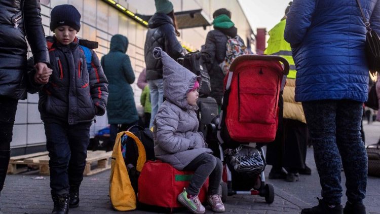 Famílias de refugiados ucranianos com filhos esperam por mais transporte no centro de registro em Przemysl, sudeste da Polônia. Foto de Wojtek RADWANSKI / AFP)