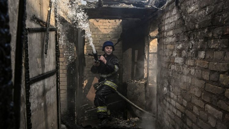 Un pompier éteint les flammes d'une maison bombardée par l'armée russe, à Kiev, le 23 mars 2022. (Aris Messinis/AFP)