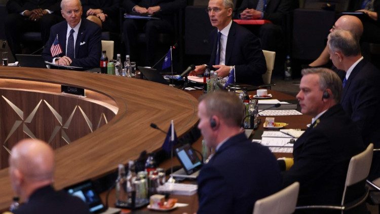 US President Joe Biden listens as NATO Secretary General Jens Stoltenberg addresses an emergency summit in Brussels