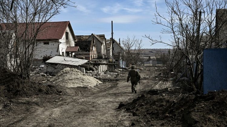 A serviceman walks through the village of Mala Rogan, east of Kharkiv, Ukraine