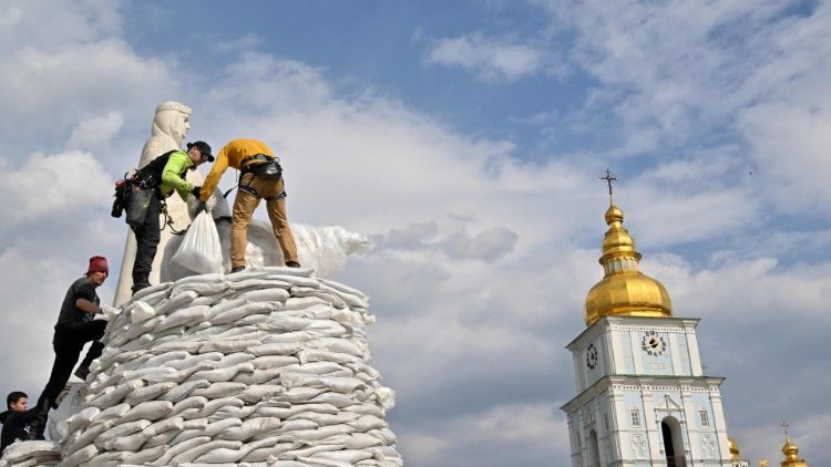 Voluntários montam sacos de areia para cobrir e proteger o Monumento à Princesa Olga, Santo André Apóstolo e os educadores Cirilo e Metódio em Kiev em 29 de março de 2022, em meio à invasão russa da Ucrânia. (Foto de Sergei SUPINSKY/AFP)