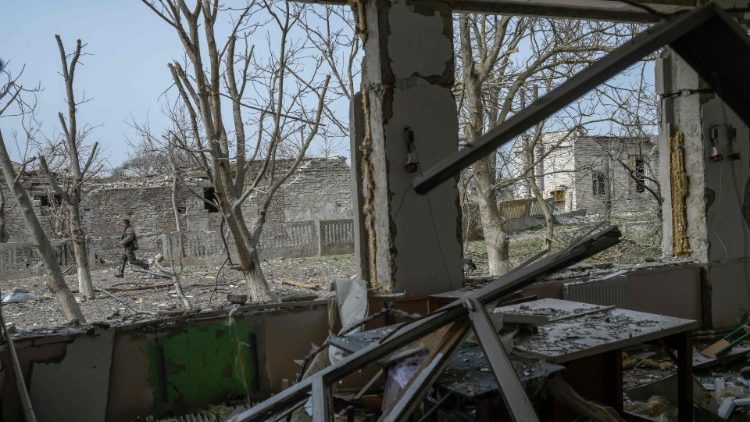 Um soldado ucraniano na frente de casa atingida por foguetes russos na vila de Zelenyi Hai, no sul da Ucrânia, entre Kherson e Mykolaiv, a menos de 5 km da linha de frente em 1º de abril de 2022, enquanto a Otan diz que não está vendo uma retirada das forças russas em Ucrânia e espera "ações ofensivas adicionais", adverte o chefe da aliança. (Foto por BULENT KILIC/AFP)