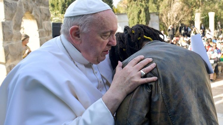 Francisco abraza a un joven migrante que compartió su testimonio durante el encuentro
