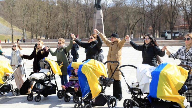 Mulheres com carrinhos de bebê e bandeiras ucranianas participam de uma manifestação sob o lema "A marcha das mães pelas crianças mortas na guerra na Ucrânia" para protestar contra a invasão da Ucrânia pela Rússia, em Vilnius, Lituânia, em 6 de abril de 2022. (Foto de PETRAS MALUKAS / AFP)