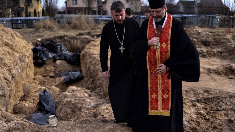 El Primado de la Iglesia greco-católica ucraniana reza ante una fosa común en Bucha.