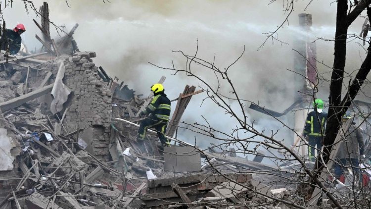 Feuerwehrleute versuchen, ein Feuer zu löschen, nachdem eine Rakete in ein Gebäude am Stadtrand von Charkiw eingeschlagen ist, 12. April 2022.