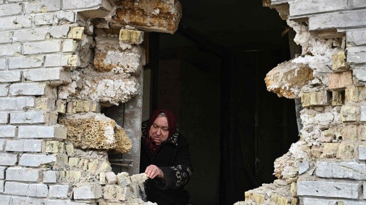 In a village northeast of Kyiv, a woman shows the hole in her house caused by shelling