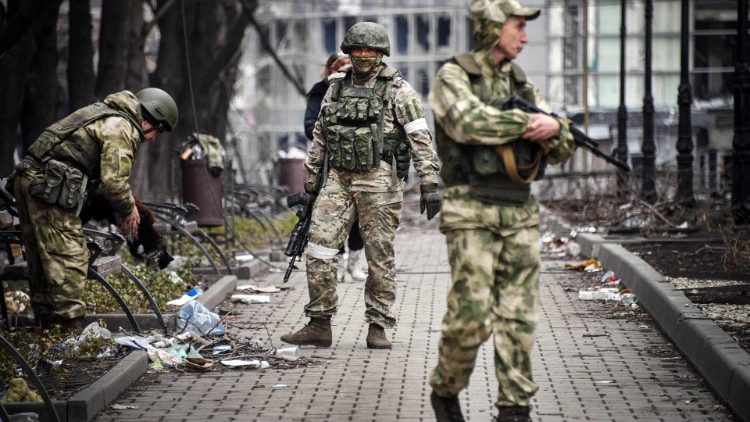 I soldati russi camminano lungo una strada a Mariupol, città portuale strategica