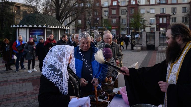 Pravoslavni svećenik blagoslivlja uskrsne košarice nakon mise u ukrajinskom gradu Zaporižžja