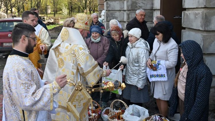 Un sacerdote bendice canastas de Pascua frente a la Iglesia greco-católica ucraniana de San Nicolás el Milagroso en Kharkiv .