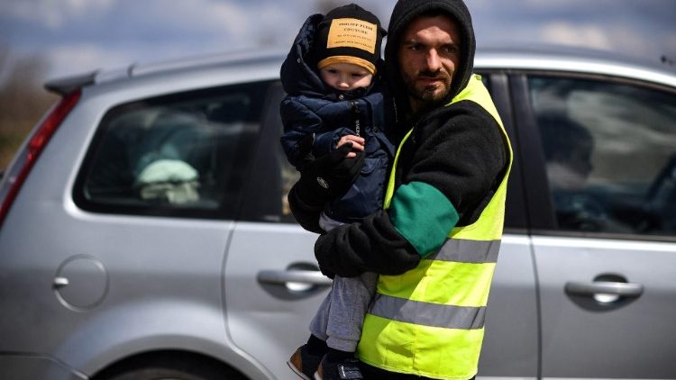  Un voluntario sostiene a un niño ucraniano refugiado tras cruzar la frontera entre Ucrania y Moldavia