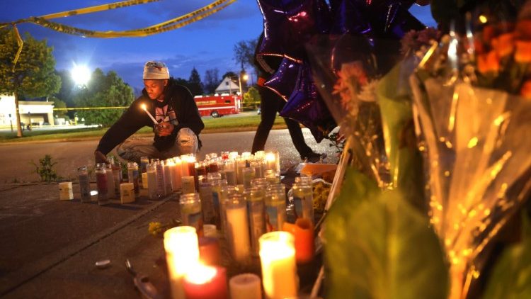 Mourners light candles at a makeshift memorial at the scene of a shooting in Buffalo, NY 