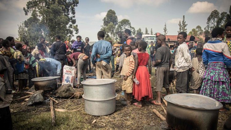 Voluntários preparam refeições para deslocados internos, fugindo dos recentes confrontos entre rebeldes do M23 e soldados congoleses, em um acampamento em Kanyarushinya, ao norte de Goma, em 27 de maio de 2022.