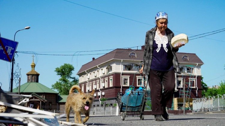 Frau mit Brot und Wasser in Mariupol, Ukraine. 1. Juni 2022
