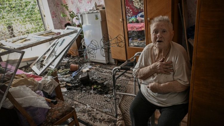 An elderly woman sits inside her bombed out house in Soledar