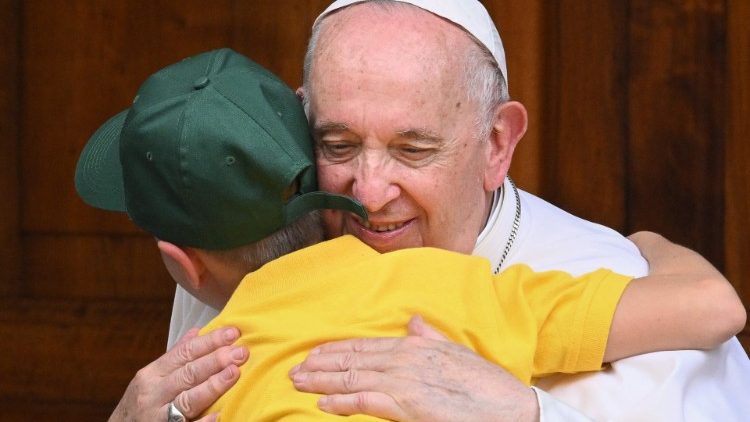 Pope Francis embraces a young Ukrainian refugee