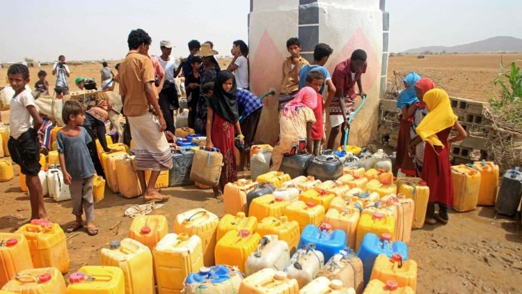 Yemenis fill their jerrycans with water at a camp for IDPs in the northern Haijah province