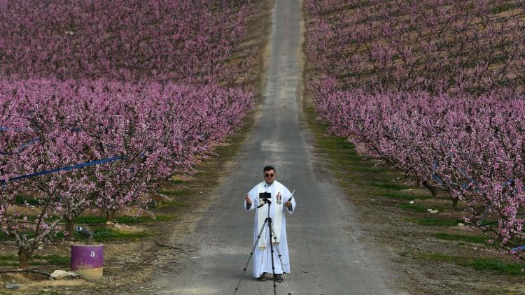 Priester in Spanien zeichnet mit seinem Handy eine Predigt auf