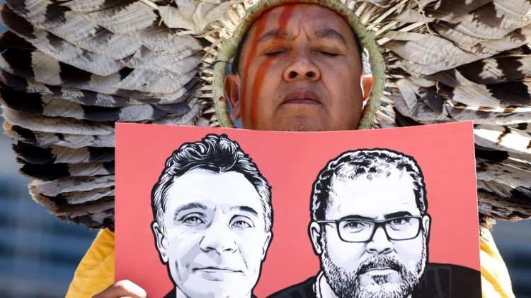 Un indígena sostiene un cartel con los retratos del periodista británico Dom Phillips y del brasileño Bruno Pereira mientras participa en una protesta en Bruselas