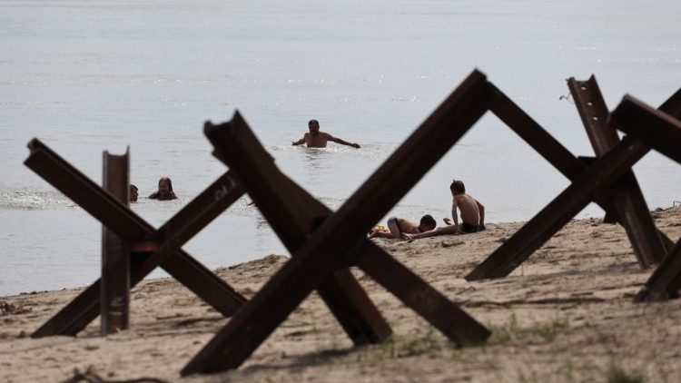 Em Izmail, região de Odessa, ucranianos em momento de relax no Rio Danúbio, com obstáculos anti-tanque nas margens. (Oleksansdr Gimanov/AFP)