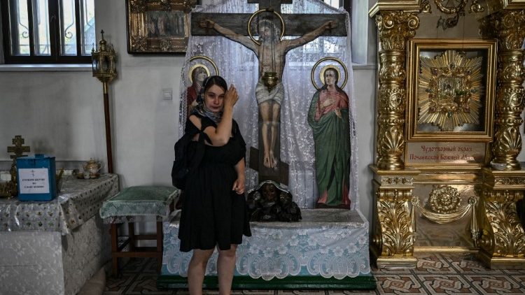 Ucraniana chora enquanto participa de uma oração de domingo em uma igreja em Kramatorsk, na região do Donbass, em 19 de junho de 2022, em meio à invasão russa da Ucrânia. (Foto: ARIS MESSINIS/AFP)