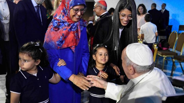 Pope Francis shakes hands with a mother at a Vatican event in June