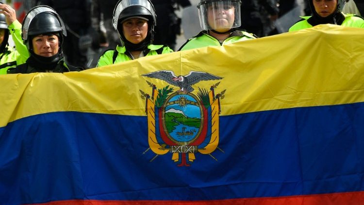 Police stand guard behind an Ecuadorian flag in the area around the National Assembly in Quito.