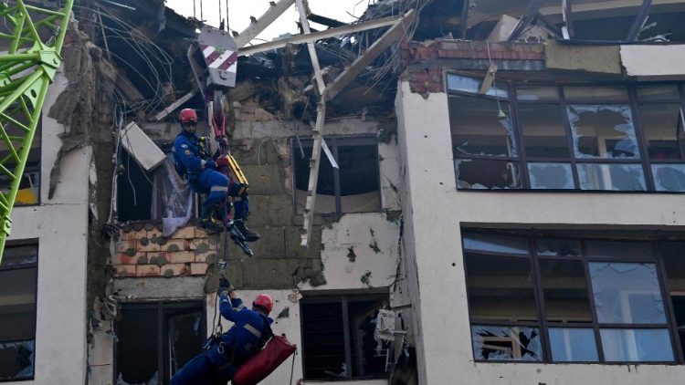  Ukrainian rescuers work outside a damaged residential building hit by Russian missiles in Kyiv on June 26, 2022, amid Russian invasion of Ukraine. - "The G7 summit must respond with more sanctions against Russia and more heavy weapons for Ukraine," urged on June 26, 2022 Dmytro Kouleba, the head of Ukrainian diplomacy, on Twitter, calling for "defeating the sick Russian imperialism." (Photo by Sergei SUPINSKY / AFP)