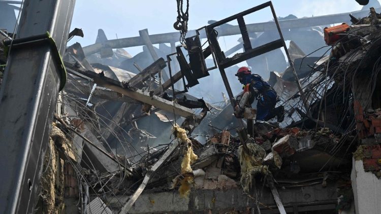  Ukrainian rescuers work outside a damaged residential building hit by Russian missiles in Kyiv on June 26, 2022, amid Russian invasion of Ukraine. - "The G7 summit must respond with more sanctions against Russia and more heavy weapons for Ukraine," urged on June 26, 2022 Dmytro Kouleba, the head of Ukrainian diplomacy, on Twitter, calling for "defeating the sick Russian imperialism." (Photo by Sergei SUPINSKY / AFP)