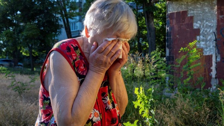 Uma idosa reage enquanto equipes de resgate evacuam o corpo de seu marido que foi morto em um ataque com foguete em uma área residencial em Kharkiv em 27 de junho de 2022. (Foto de SERGEY BOBOK/AFP)