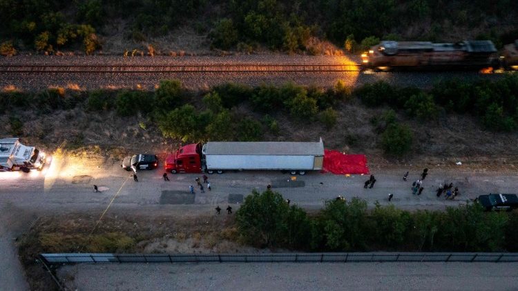 Members of law enforcement investigate the scene in which the trailer containing dozens of migrants was found, San Antonio, Texas