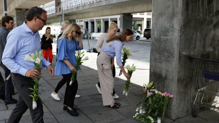People lay flowers and candles near the site of a deadly shooting at a shopping mall in Copenhagen