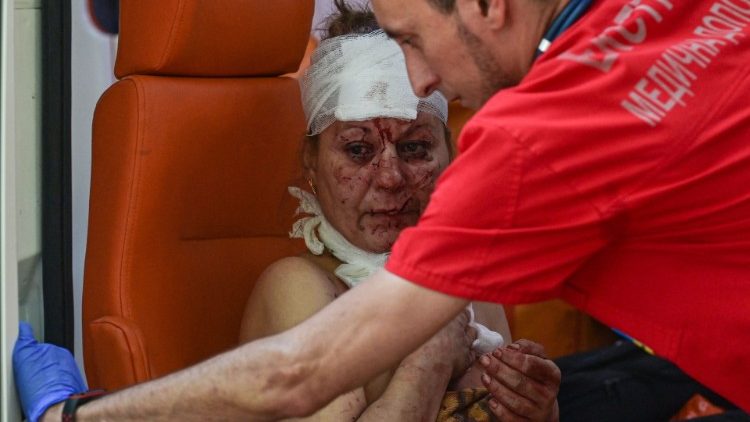 Uma mulher ferida é socorrida por uma enfermeira de ambulância após um ataque aéreo no pátio do hotel Industria e residências civis no centro de Kramatorsk, em 7 de julho de 2022. - Um ataque aéreo em 7 de julho de 2022 matou pelo menos uma pessoa e feriu vários outros em Kramatorsk, um centro administrativo da região leste da Ucrânia sob ataque russo, disseram jornalistas da AFP. (Foto de MIGUEL MEDINA/AFP)