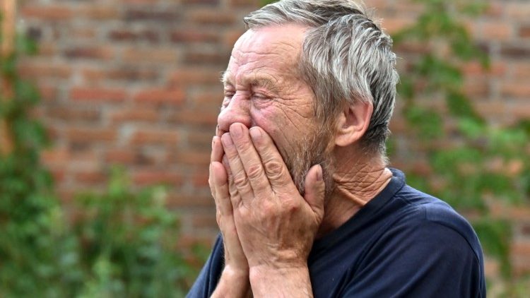 Um homem chora por sua esposa que morreu como resultado de um bombardeio de múltiplos sistemas de lançamento de foguetes para uma área residencial em Kharkiv em 7 de julho de 2022 em meio à invasão russa da Ucrânia. - Três civis foram mortos e 5 feridos como resultado do bombardeio do escritório do promotor da região de Kharkiv. (Foto de SERGEY BOBOK/AFP)