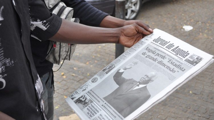 Um homem segura uma cópia do Jornal de Angola com uma manchete sobre a morte do ex-presidente angolano José Eduardo Dos Santos em Luanda em 9 de junho de 2022. (Foto de Julio PACHECO NTELA/AFP)