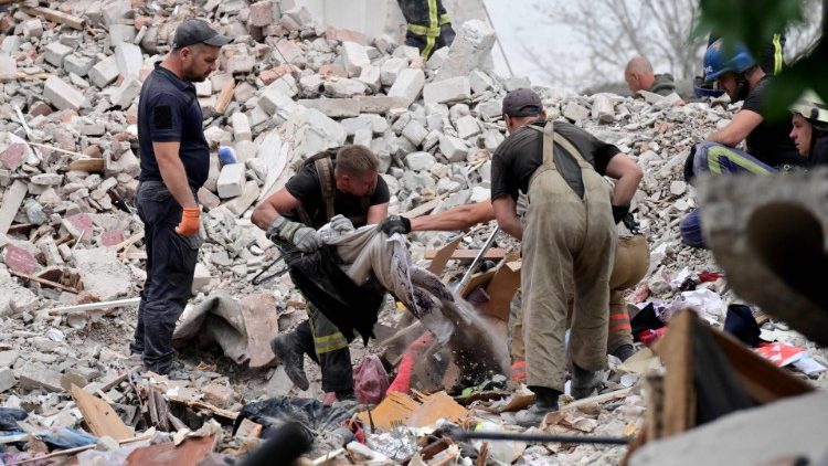 Soccorritori tra le macerie dopo un bombardamento (luglio 2022, Afp).
