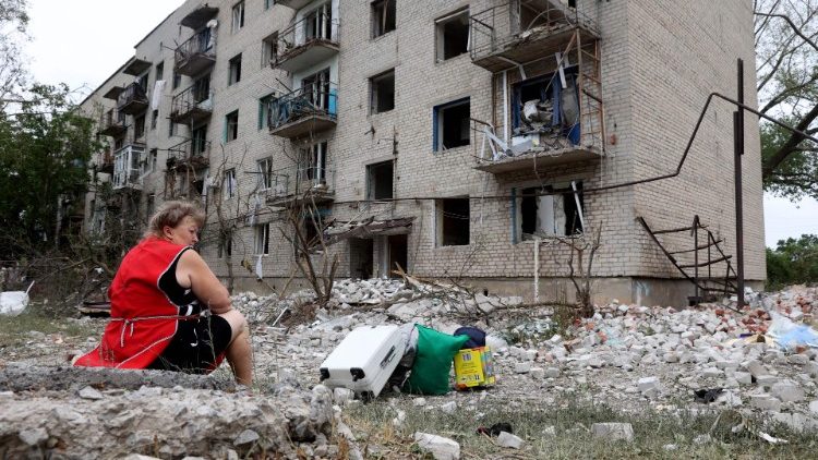Uma mulher, moradora local, senta-se ao lado de seus pertences do lado de fora de um prédio que foi parcialmente destruído após um bombardeio em Chasiv Yar, leste da Ucrânia, em 10 de julho de 2022. - O prédio de quatro andares foi atingido por um míssil russo Hurricane, Pavlo Kyrylenko, governador da região de Donetsk que o exército russo está tentando conquistar, disse em 10 de julho de 2022 no Telegram. (Foto de Anatolii Stepanov/AFP)