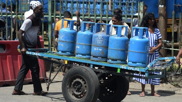 Um homem empurra um carrinho carregado com cilindros de Gás Liquefeito de Petróleo (GLP) coletados em um ponto de distribuição em Colombo em 12 de julho de 2022. (Foto de Arun SANKAR/AFP)