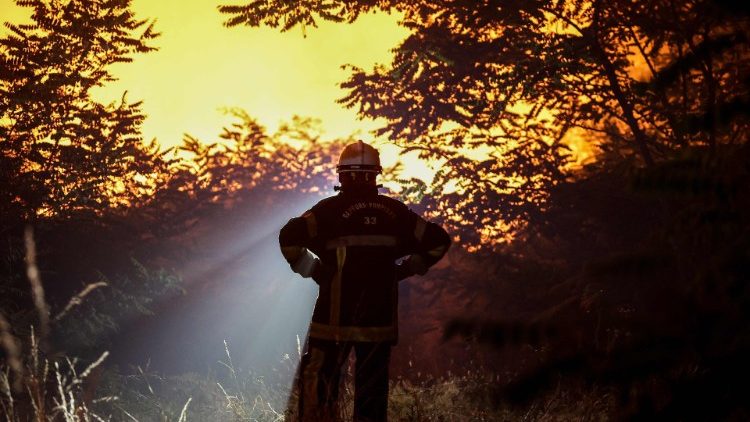 A firefighter stands near a blaze in southwestern France