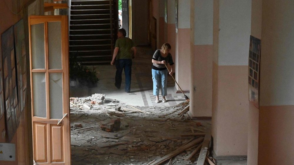 Funcionrios limpam dentro da Casa da Cultura danificada aps ataques noturnos na cidade de Chuhuiv, regi?o de Kharkiv, em 25 de julho de 2022, em meio  invas?o russa da Ucr?nia. - A invas?o russa da Ucr?nia entrou em seu sexto ms em 24 de julho de 2022, um dia depois de greves no porto de Odessa amea?arem a implementa??o do acordo sobre a retomada das exporta??es de gr?os bloqueadas pela guerra. (Foto de SERGEY BOBOK/AFP)
