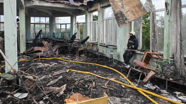 Um bombeiro descansa após apagar um incêndio no prédio de uma escola profissionalizante após um ataque com mísseis na cidade ucraniana de Kharkiv, em 30 de julho de 2022, em meio à invasão russa da Ucrânia. (Foto de SERGEY BOBOK/AFP)