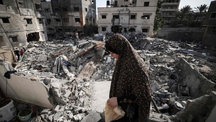 Una donna palestinese tra le macerie di Gaza City