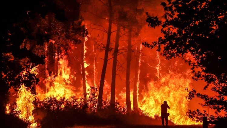  A silhouette is seen in front of flames at a wildfire near Belin-Beliet, southwestern France