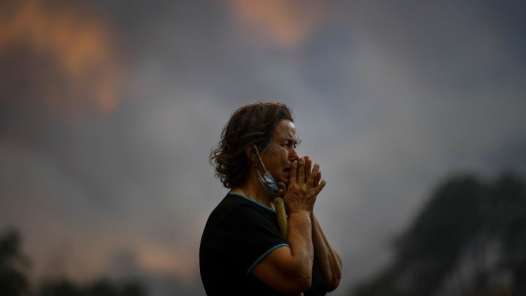 Une femme observe l'avancée d'un feu de forêt à Orjais, à Covilha, dans le centre du Portugal, le 16 août 2022.