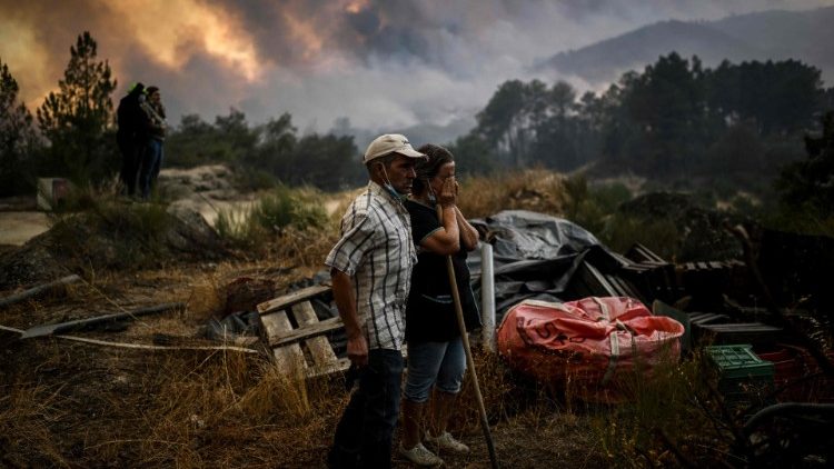 Des habitants portugais face au feu ravageant la ville de Covilha, au Portugal, le 16 août 2022. 
