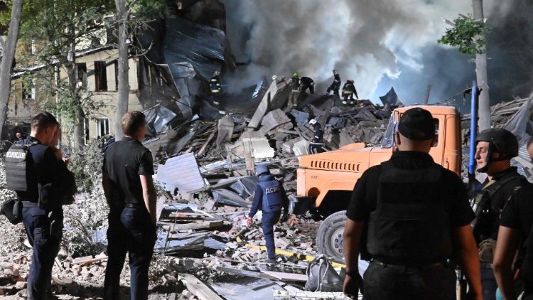 Equipes de resgate inspecionam o local de um albergue destruído como resultado de um ataque com mísseis na segunda maior cidade ucraniana de Kharkiv no final de 17 de agosto de 2022, em meio à invasão militar da Ucrânia pela Rússia. (Foto de SERGEY BOBOK/AFP)