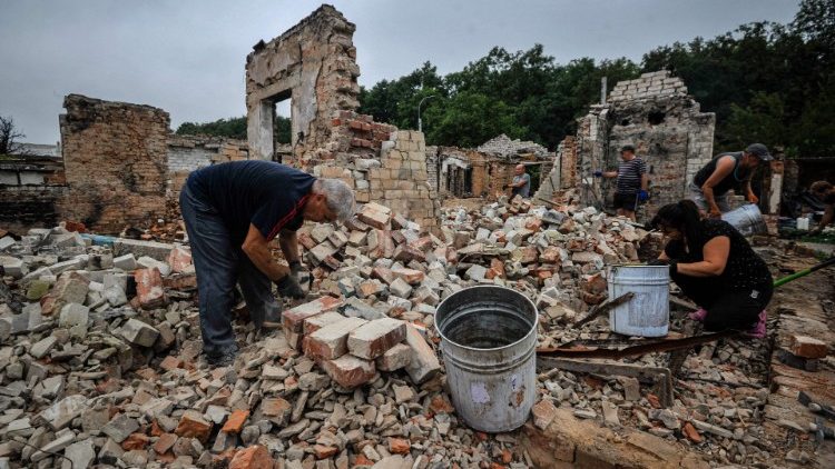 Voluntários limpam os escombros de uma casa destruída como resultado do bombardeio na cidade de Chernihiv em 20 de agosto de 2022, em meio à invasão da Ucrânia pela Rússia. - A retirada da Rússia de Chernihiv em abril, após um ataque de um mês deixou para trás uma cidade devastada que a Ucrânia precisará de ajuda externa maciça e muitos anos de trabalho para restaurar. (Foto de SERGEI CHUZAVKOV/AFP)